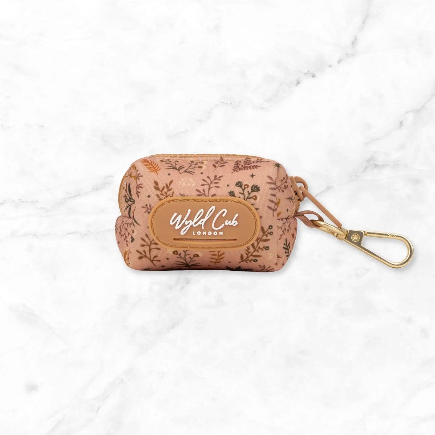 Brown floral patterned Wild Cub London pouch with gold carabiner clip on white marble background